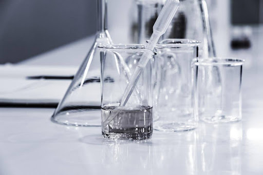 An image of a lab setup with a beaker on a table with fluid being drawn out of the beaker