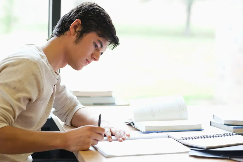 A writer sitting and writing on a desk